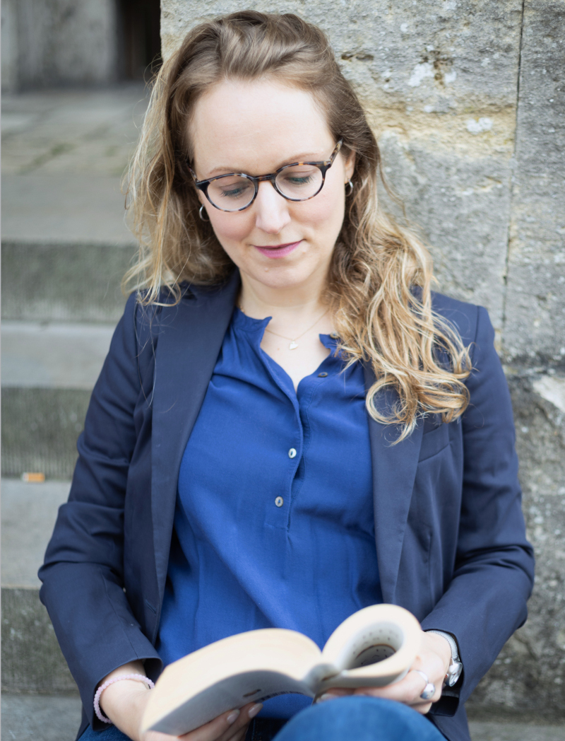 Portrait of Mia Kos reading outdoors, professional development